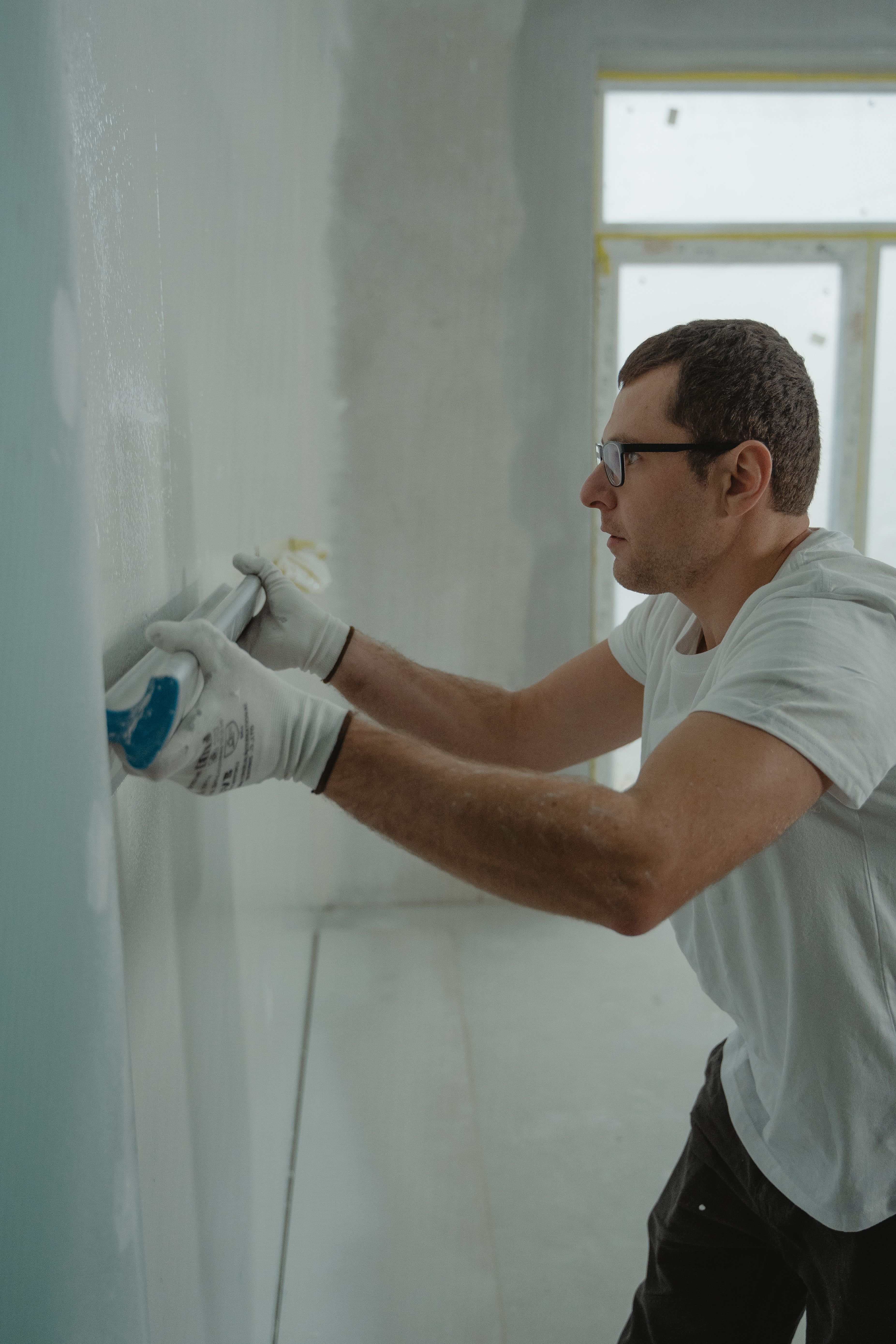 Profesional aplicando compuesto para juntas en el techo de una vivienda